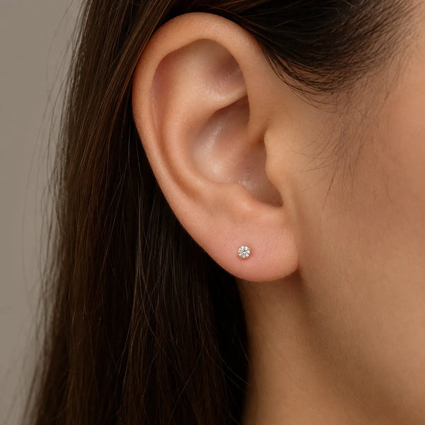 10K yellow gold 3mm round CZ stud earrings showing side and back view with push-back posts on marble surface