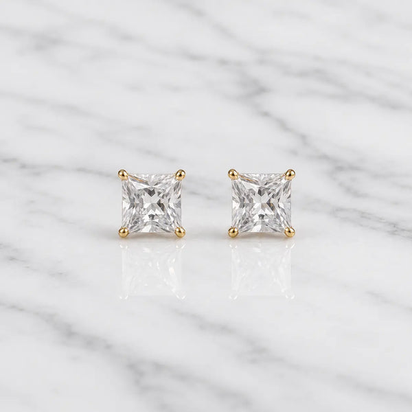 10K yellow gold 4mm princess-cut CZ stud earrings in four-prong settings on white marble surface