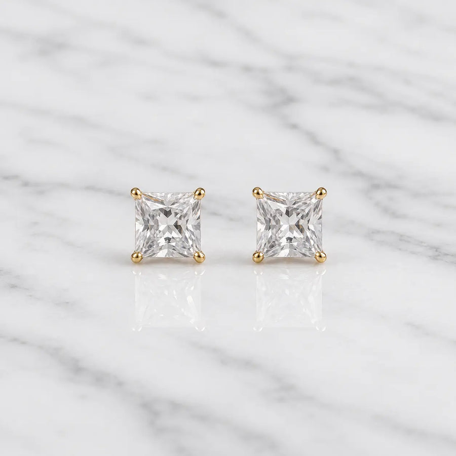 10K yellow gold 4mm princess-cut CZ stud earrings in four-prong settings on white marble surface