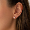 10K yellow gold 4mm princess-cut CZ stud earring worn on ear showing petite scale and fit