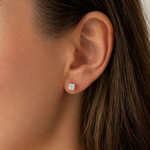 10K yellow gold 4mm princess-cut CZ stud earring worn on ear showing petite scale and fit