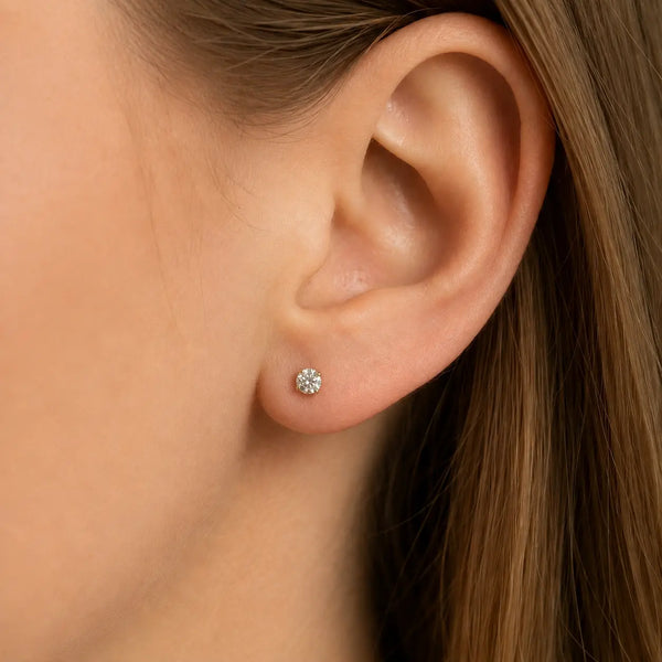 10K yellow gold 4mm round CZ stud earring worn on ear showing everyday scale and fit