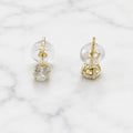 10K yellow gold 4mm round CZ stud earrings showing side and back view with push-back posts on marble surface