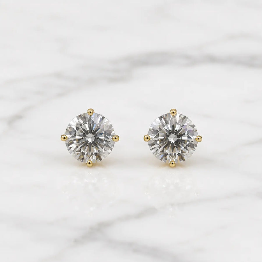 10K yellow gold 5mm round CZ stud earrings in polished four-prong settings on white marble surface