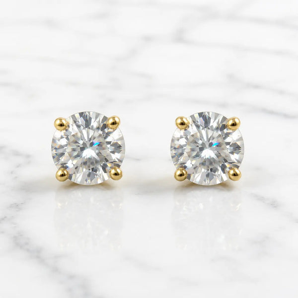 10K yellow gold 6mm round CZ stud earrings in polished four-prong settings on white marble surface