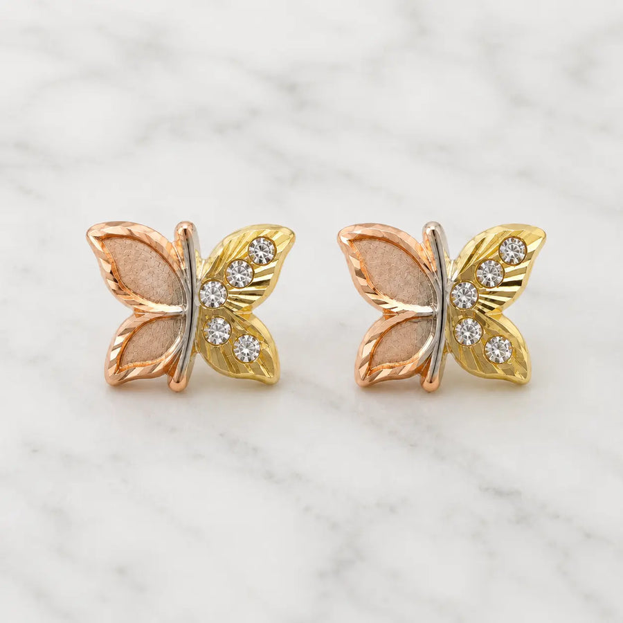 14K tri-color gold butterfly stud earrings with rose, yellow, and white gold details on marble surface