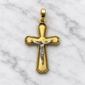 14K two-tone gold crucifix pendant with white gold corpus on brushed yellow gold cross on white marble surface