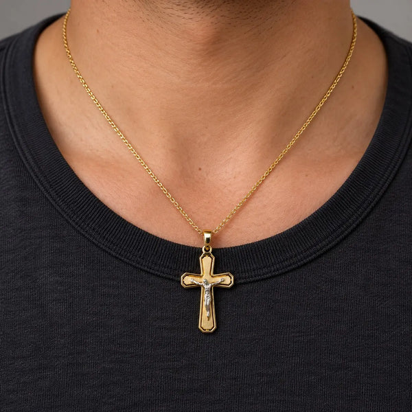 14K two-tone gold crucifix pendant with white gold corpus worn on a gold cable chain over a black crew-neck shirt