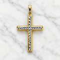 14K two-tone gold diamond-cut cross pendant with white gold faceted center strip on white marble surface