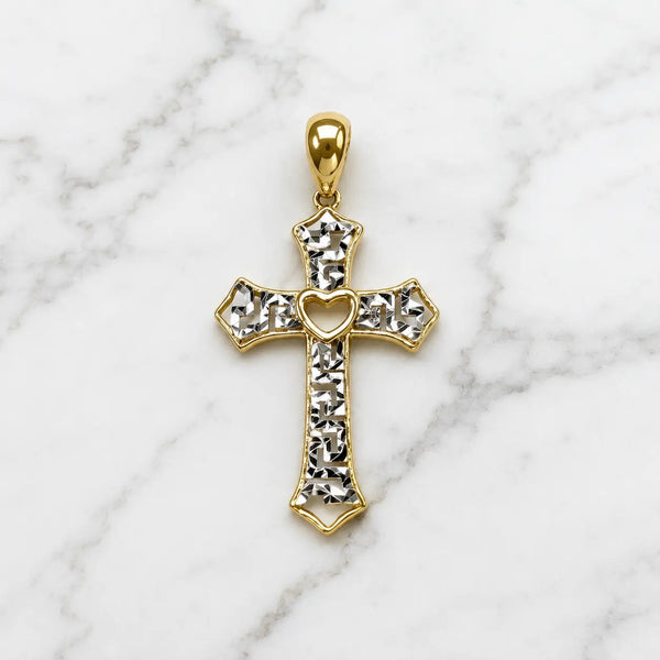 14K two-tone gold diamond-cut cross pendant with white gold accents and open-heart center on marble surface