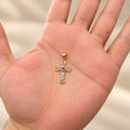 14K two-tone gold diamond-cut heart cross pendant held in hand to show its petite 15.2 x 28.8mm scale