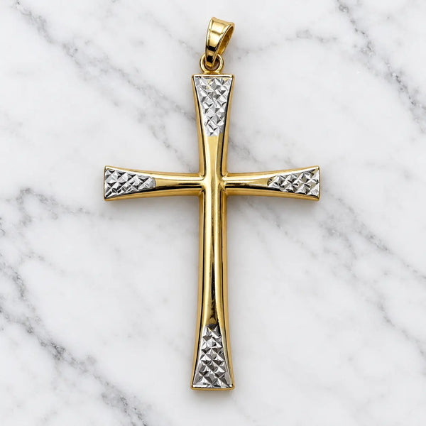 14K two-tone gold flared cross pendant with white gold diamond-cut panels at the arm ends on white marble surface