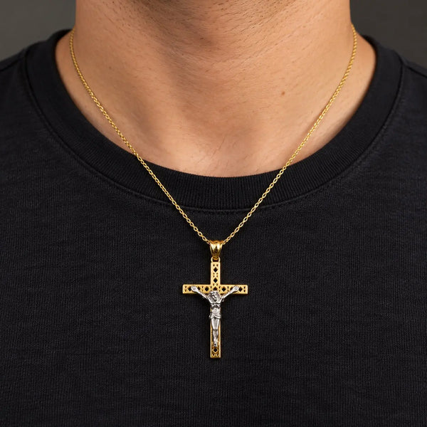 14K two-tone gold crucifix pendant with white gold corpus worn on a gold cable chain over a black crew-neck shirt