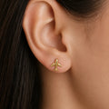 14K yellow gold airplane stud earring worn on ear showing petite travel-inspired design and scale