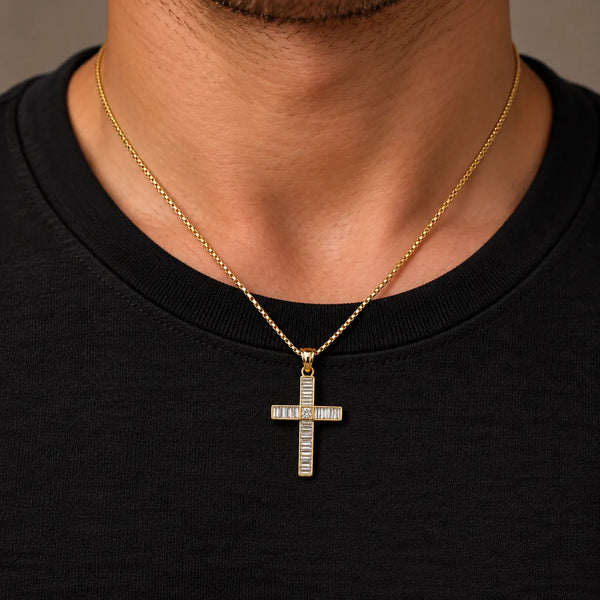 14K yellow gold baguette CZ cross pendant worn on a gold box chain at a man's neckline over a black shirt