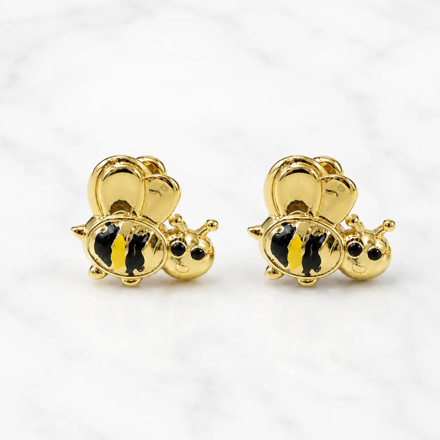 14K yellow gold bee stud earrings with black enamel accents and polished wings on marble surface