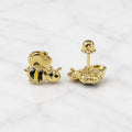 14K yellow gold bee stud earrings with black and yellow striped detail and screw backs on marble surface