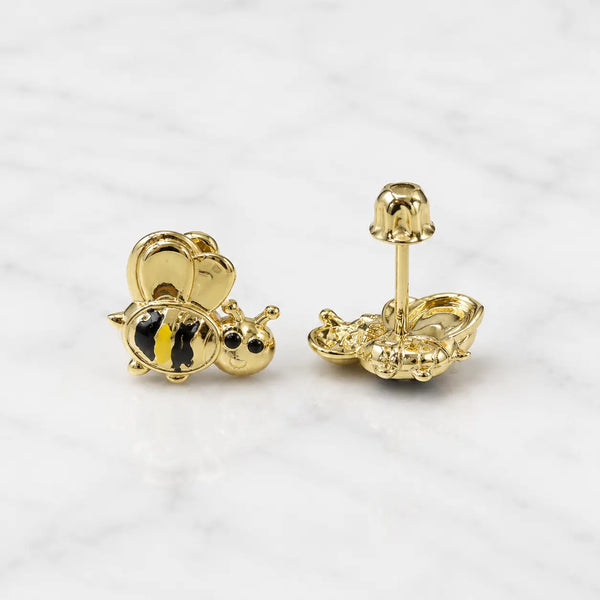 14K yellow gold bee stud earrings with black and yellow striped detail and screw backs on marble surface