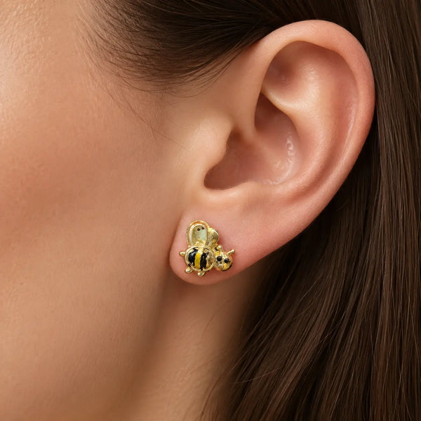 14K yellow gold bee stud earring worn on ear showing black and yellow striped detail and size
