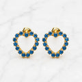 14K yellow gold blue CZ heart screw back stud earrings with open heart design on marble surface