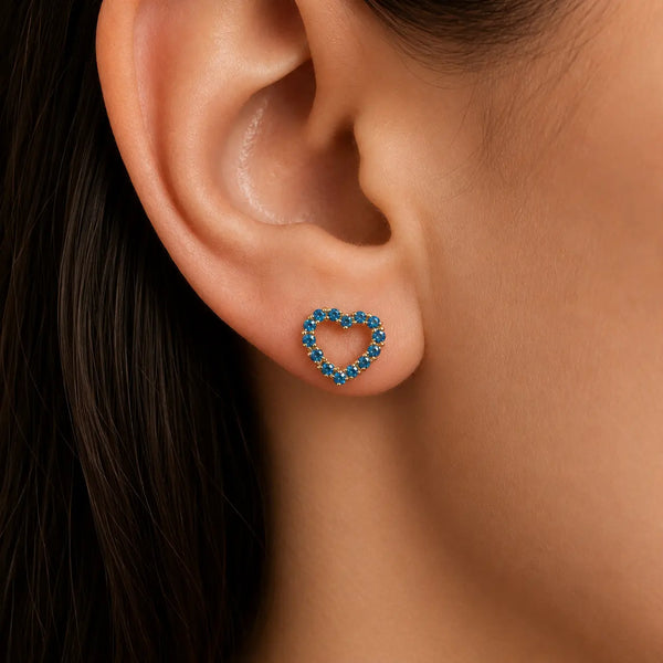 14K yellow gold blue CZ open heart stud earring worn on ear showing petite scale and color