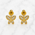 14K yellow gold CZ butterfly screw back stud earrings with clear stones and beaded wing details on marble surface