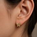 14K yellow gold CZ butterfly stud earring worn on ear showing petite scale and sparkle