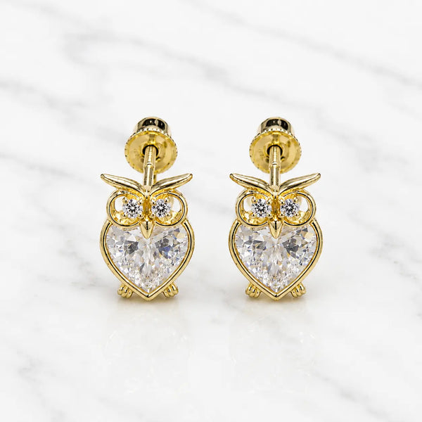 14K yellow gold owl screw back stud earrings with heart-shaped clear CZ body on marble surface