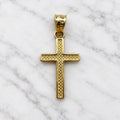 Back view of 14K yellow gold textured cross pendant with recessed geometric pattern on marble surface