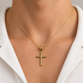 14K yellow gold textured cross pendant worn on a fine chain showing its petite scale and fit