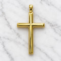 Back view of 14K yellow gold polished cross pendant showing smooth polished back and tapered bail on white marble surface