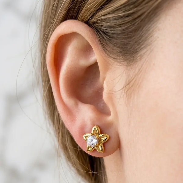 14K yellow gold 5-petal flower CZ stud earring worn on ear showing size and fit against skin