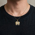 14K yellow gold Holy Bible open book pendant worn on a thin gold chain over a dark crew-neck shirt