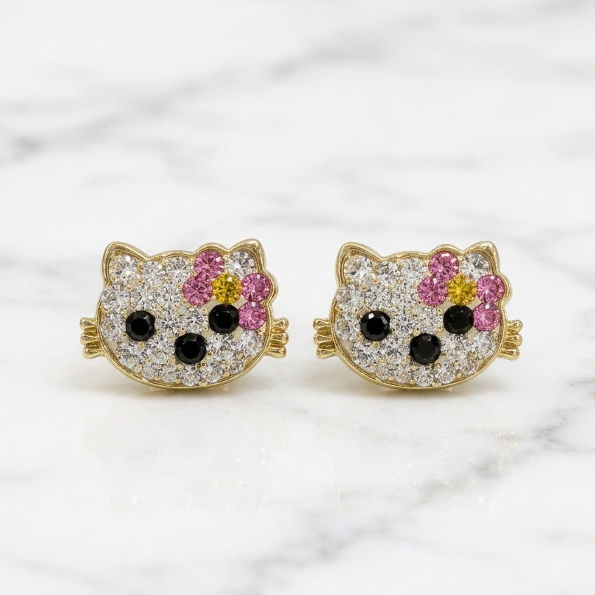 14K yellow gold multicolor CZ cat face stud earrings with pink bow and black accents on marble surface