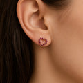 14K yellow gold pink CZ open heart stud earring worn on ear showing petite scale and sparkle