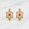 14K yellow gold turtle stud earrings with pink center CZ and clear CZ accents on marble surface