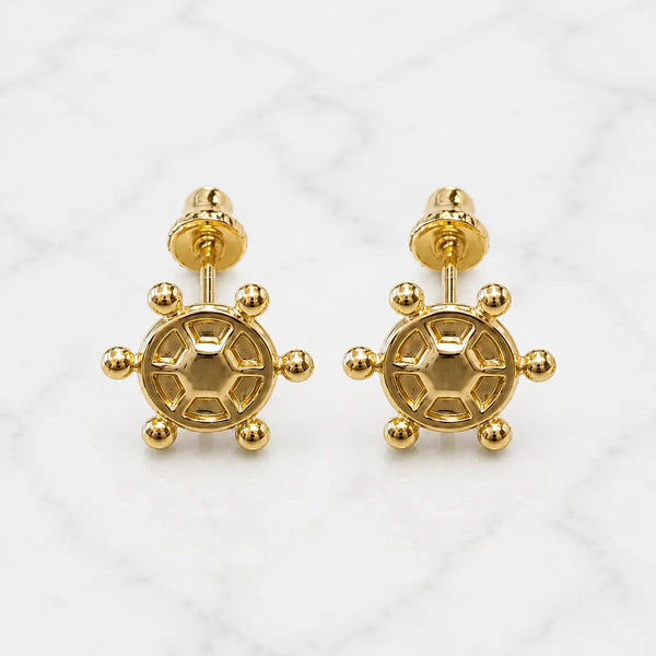 14K yellow gold ship wheel screw back stud earrings with polished nautical design on marble surface