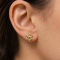 14K yellow gold ship wheel stud earring worn on ear showing petite nautical design and scale