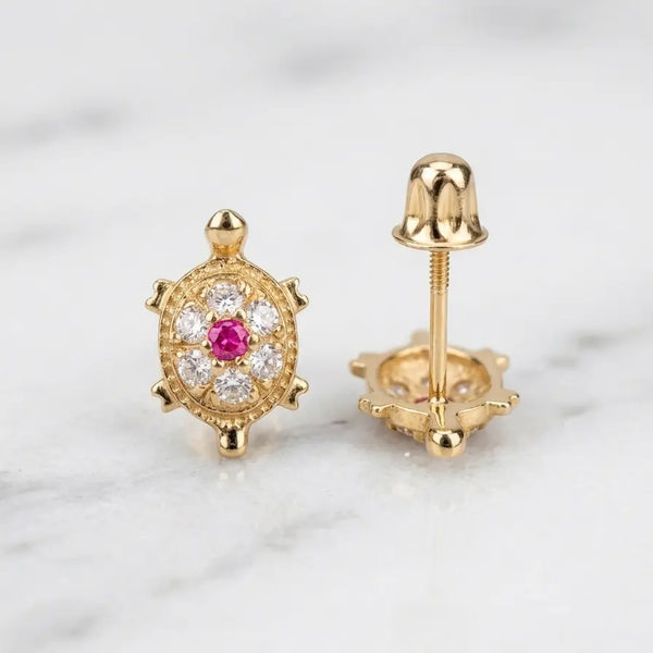 14K yellow gold turtle stud earrings with red CZ center and white CZ cluster shown front and back view on marble surface