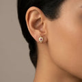 14K yellow gold turtle CZ stud earrings worn on ear showing size and red center stone detail