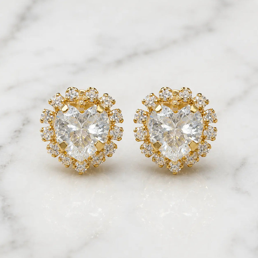 14K yellow gold white CZ heart halo stud earrings with clear CZ accent stones on marble surface