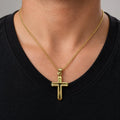 14K yellow gold polished grooved cross pendant worn on a gold chain at a man's neckline over a black shirt