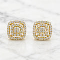 Gold tone over sterling silver 1 CTW moissanite cushion cluster stud earrings on white marble surface