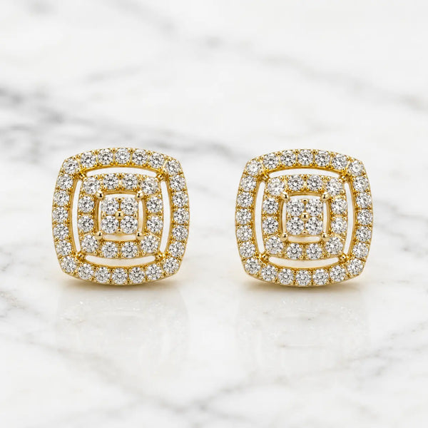 Gold tone over sterling silver 1 CTW moissanite cushion cluster stud earrings on white marble surface