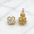 Gold tone moissanite floral stud earrings front and back view with screw closures on marble surface