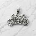 Back view of sterling silver motorcycle pendant showing open CZ settings and polished framework on marble surface