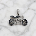 Sterling silver motorcycle pendant with black and clear CZ stones and baguette CZ detail on marble surface