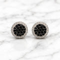 Sterling silver black CZ pavé halo stud earrings front pair with clear CZ border on marble surface