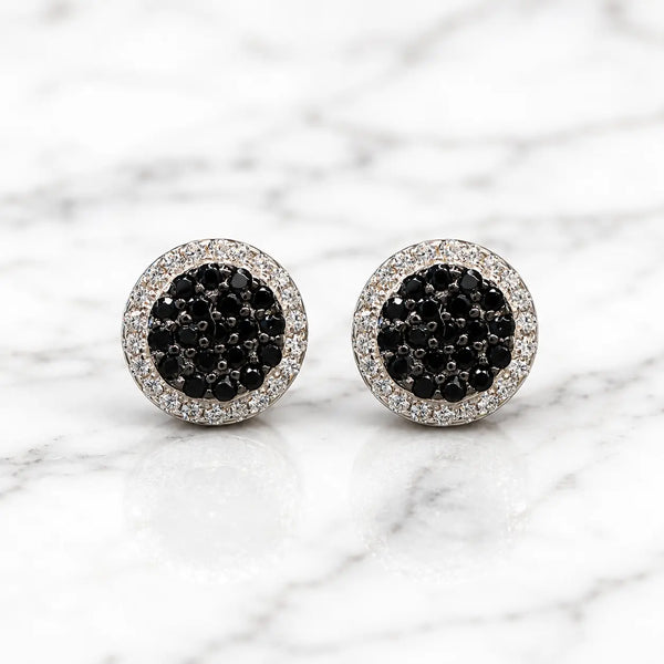 Sterling silver black CZ pavé halo stud earrings front pair with clear CZ border on marble surface