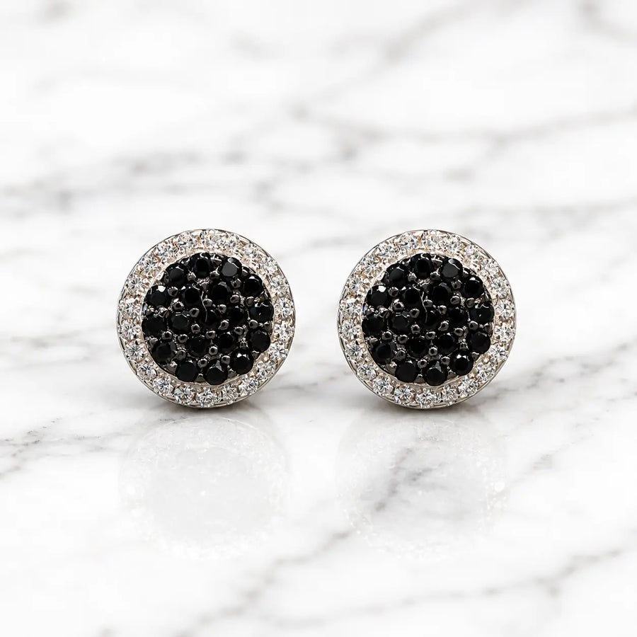 Sterling silver black CZ pavé halo stud earrings front pair with clear CZ border on marble surface